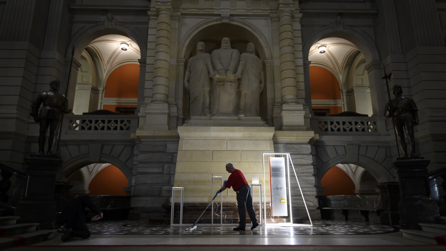 Eine Person reinigt den Boden in der Eingangshalle des Parlamentgebaeudes waehrend der Coronavirus (Covid-19) Pandemie, am Montag, 16. Maerz 2020 in Bern. Die letzte Woche der der Fruehlingssession de ...