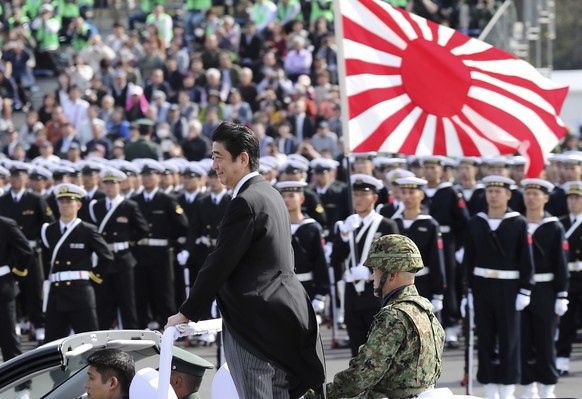 FILE - In this Oct. 23, 2016 file photo, Japanese Prime Minister Shinzo Abe, center standing, reviews members of Japan Self-Defense Forces (SDF) during the Self-Defense Forces Day at Asaka Base, north ...