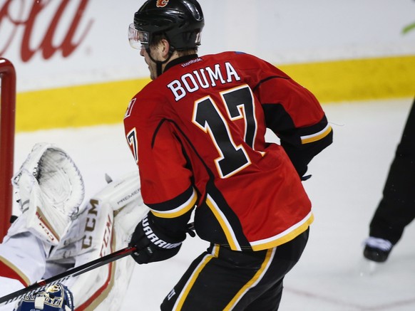 Florida Panthers goalie Roberto Luongo, left, tries to stop a goal from Calgary Flames&#039; Lance Bouma during third period NHL hockey action in Calgary, Tuesday, Jan. 17, 2017. (Jeff McIntosh/The Ca ...