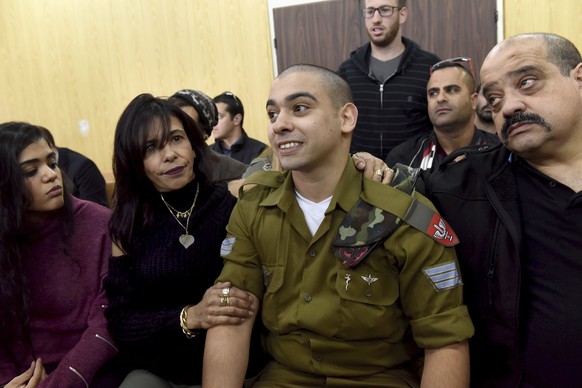 FILE -- In this January 24, 2017 file photo, Israeli soldier Sgt. Elor Azaria attends a sentencing hearing in the military court surrounded by his family, in Tel Aviv, Israel. The Israeli army said a  ...