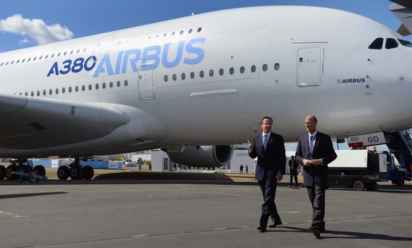Britain&#039;s Prime Minister David Cameron second right, and Tom Enders, the chief executive of Airbus Group, walk by an Airbus A380, during a visit to the 2014 Farnborough Airshow in Hampshire, Engl ...