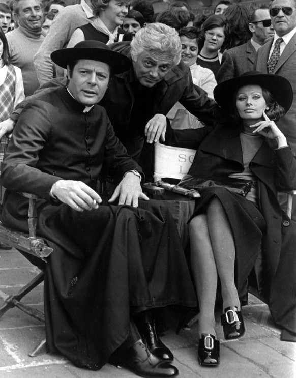Sophia Loren und der als katholische Priester verkleidete Schauspieler Marcello Mastroianni pausieren ein bisschen während der Dreharbeiten zu ihrem Film «La Moglie Del Prete» in Padua, 1970.