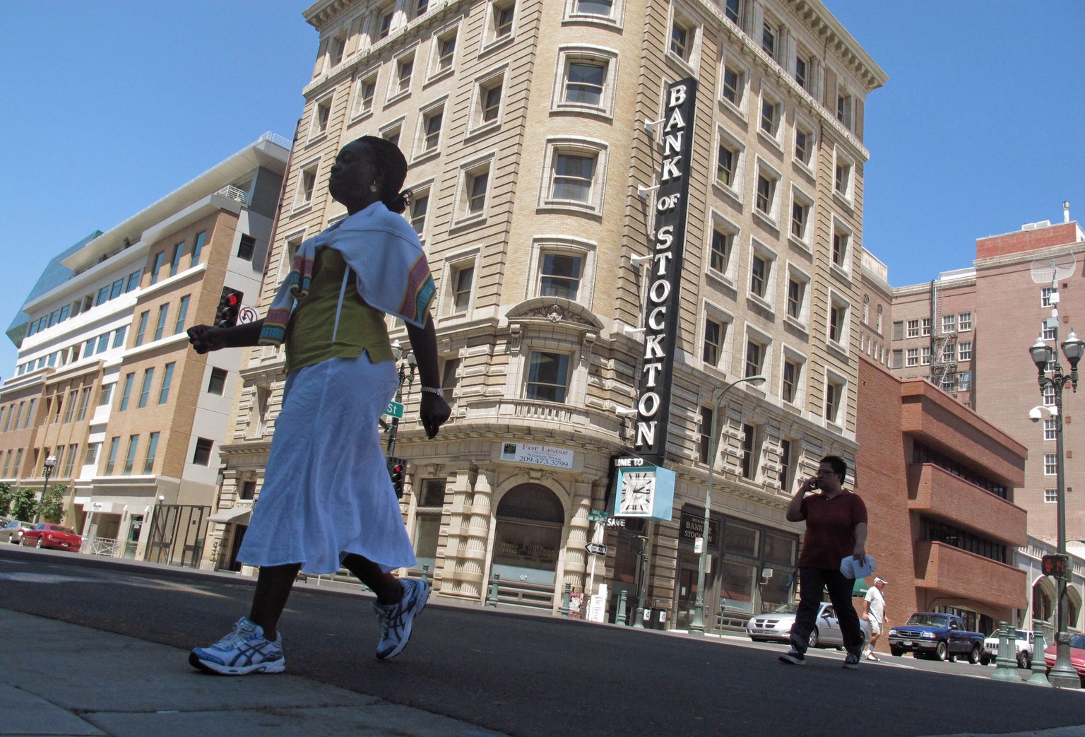 FILE - In this June 27, 2012 file photo, pedestrians cross a street near the Bank of Stockton in Stockton, Calif. A judge overseeing California’s largest city to file bankruptcy on Tuesday, July 8, 20 ...