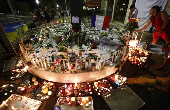 epa05427098 As night falls, people gather in front of the memorial set on the &#039;Promenade des Anglais&#039; where the truck crashed into the crowd during the Bastille Day celebrations, in Nice, Fr ...