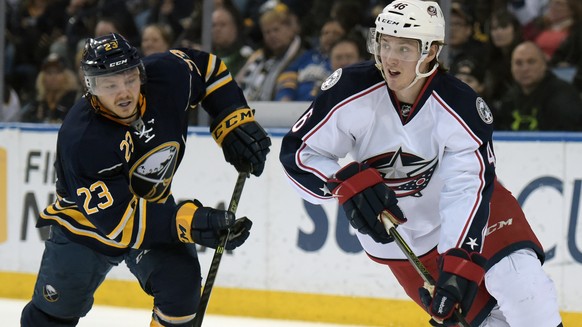 Buffalo Sabres center Sam Reinhart (23) pursues as Columbus Blue Jackets defenseman Dean Kukan (46), of the Czech Republic, looks to pass the puck up ice during the first period of an NHL hockey game, ...