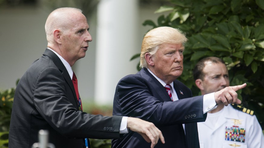 epa06025042 US President Donald J. Trump (C), along with Director of Oval Office Operations Keith Schiller (L), leave the South Lawn after welcoming the 2016 NCAA Football National Champions, the Clem ...