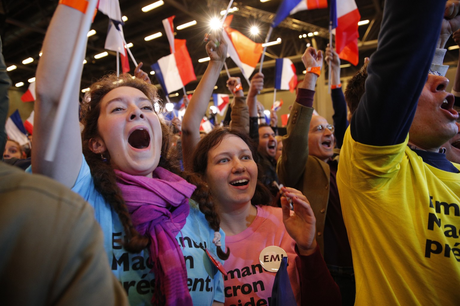 Supporters of French centrist presidential candidate Emmanuel Macron react at his election day headquarters as the first partial official results and polling agencies projections are announced in Pari ...
