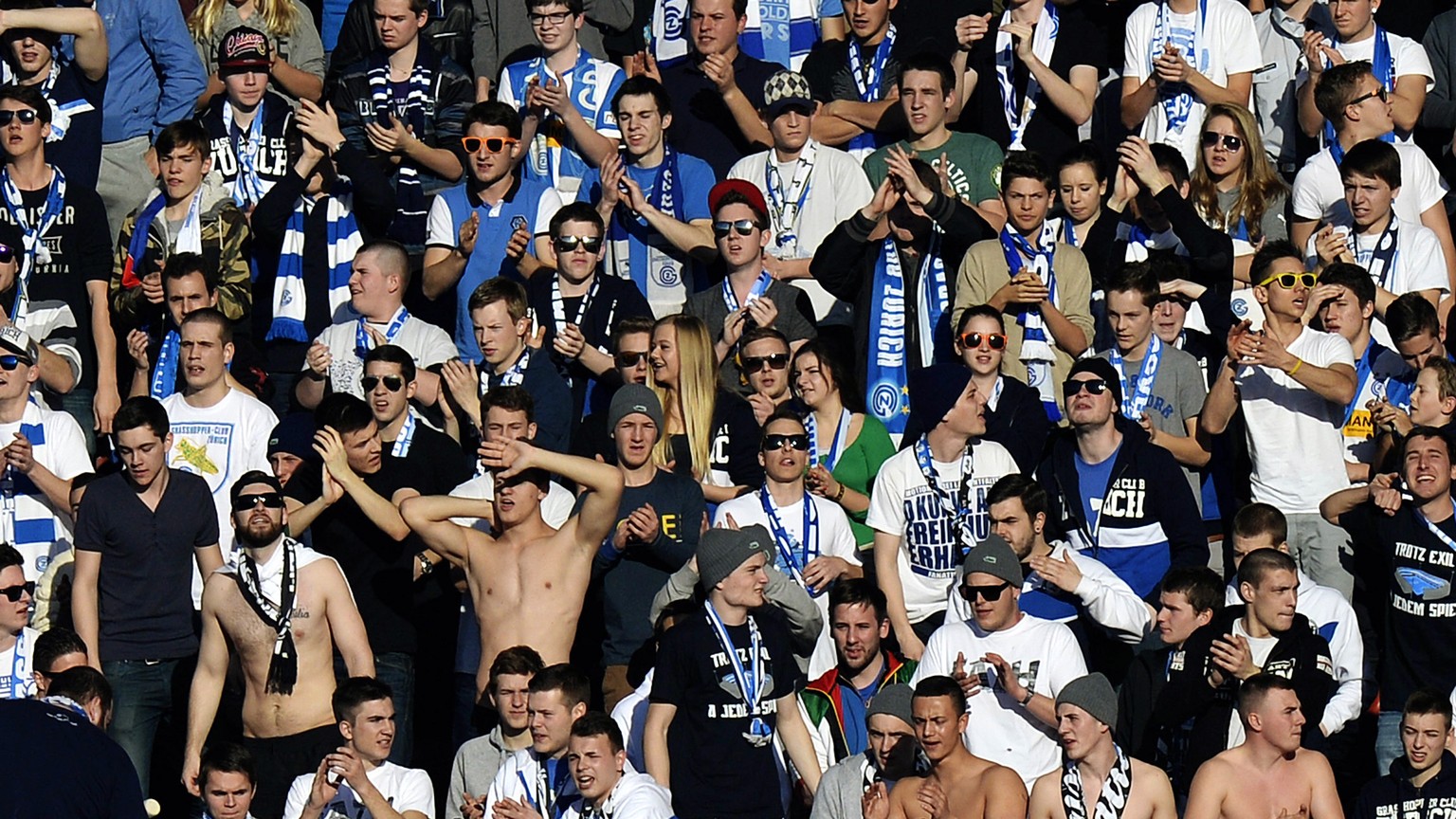 Grasshopper Fans geniessen ein paar warme Sonnenstrahlen beim Fussball Meisterschaftsspiel der Super League zwischen dem Grasshopper Club Zuerich und dem FC Basel am Sonntag, 23. Februar 2014, im Letz ...