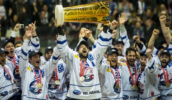 Mark Bastl, Mitte, jubelt mit dem Meisterpokal nach dem vierten Playoff Finalspiel der National League A zwischen den Kloten Flyers und den ZSC Lions, am Samstag, 19. April 2014, in der Kolping Arena  ...