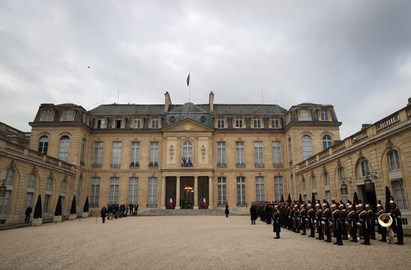 Republican guards, right, line up in the courtyard of the presidential Elysee Palace, in Paris, Friday, April 14, 2017. The two-round presidential election is set for April 23 and May 7. (AP Photo/Chr ...