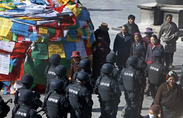 Policemen from the Special Weapons and Tactics (SWAT) team patrol on a street outside Jokhang Monastery in Lhasa, Tibet autonomous region, March 14, 2014. Picture taken March 14, 2014. REUTERS/Jacky C ...