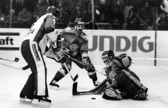 Goalie Robert Meuwly, SC Fribourg-Gotteron, beobachtet von Gagnon, Mitte, versucht einen Schuss des Kloteners Mongrain, links, abzuwehren, aufgenommen am 16. Oktober 1984 in Kloten beim Nationalliga A ...