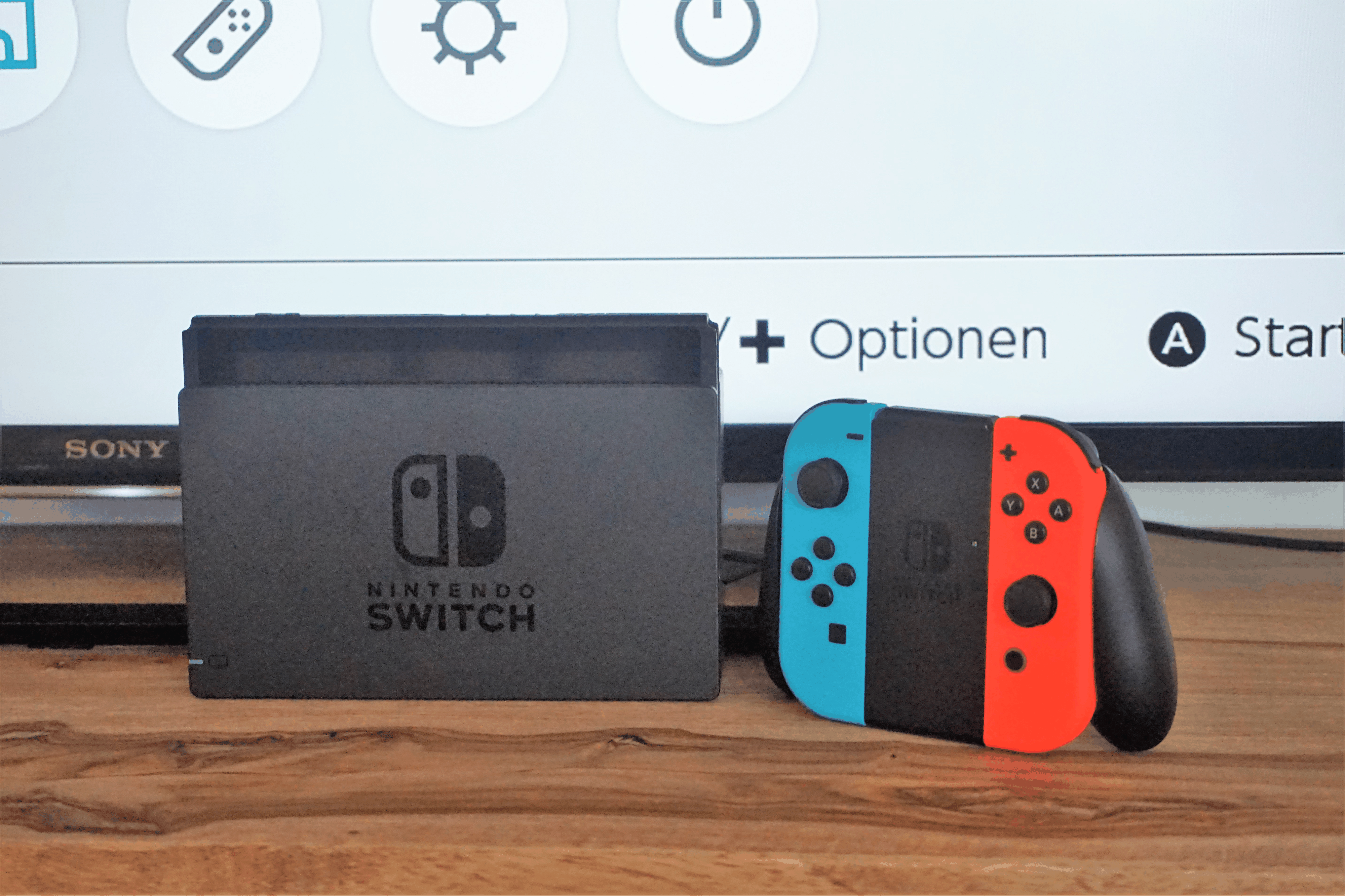 Die Switch in der Docking-Station zum Anschluss an den Fernseher, rechts der mitgelieferte Controller.