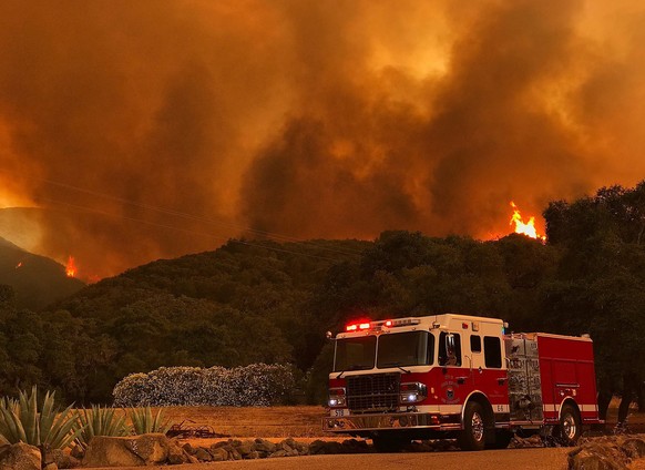 epa06077308 A handout photo made available by the Santa Barbara County Fire Department showing a Santa Barbara City Fire department vehicle parked to provide structure protection to a home on Highway  ...