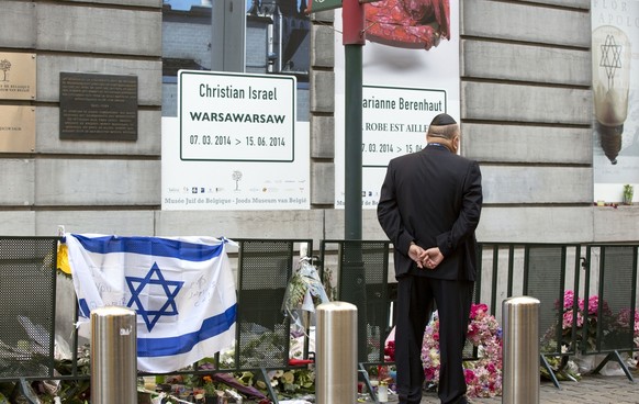 A man stops to pay his respects prior to a service for the victims of a shooting at the Jewish Museum in Brussels, on Monday, June 2, 2014. Police have arrested a suspect after three people were kille ...