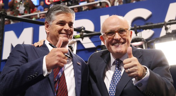 epa05431165 Fox News host SEan Hannity (L) and former New York Ciity Mayor Rudy Giuliani (R) on the floor before the start of the second session during the first day of the 2016 Republican National Co ...