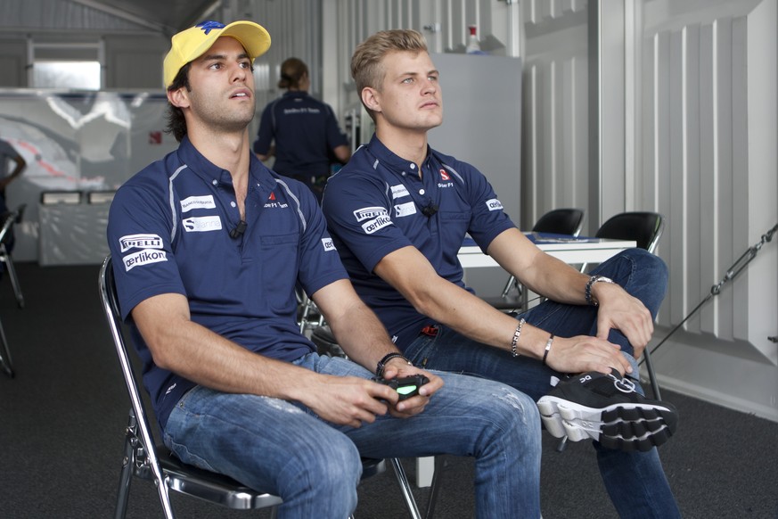 Sauber&#039;s F1 team Felipe Nasr, left, of Brazil, plays a car video game seated next to his teammate Marcus Ericsson, of Sweden, at their team&#039;s pit inside the Hermanos Rodriguez racetrack in M ...