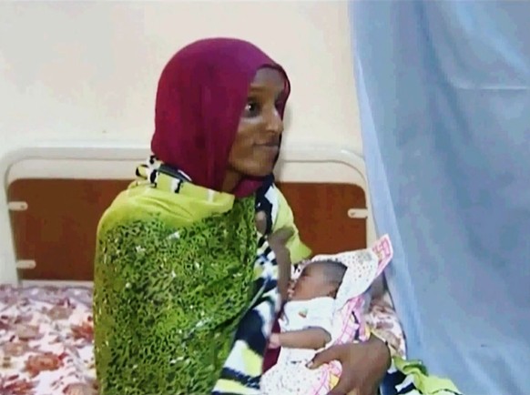 FILE - In this file image made from an undated video provided Thursday, June 5, 2014, by Al Fajer, a Sudanese nongovernmental organization, Meriam Ibrahim breastfeeds her newborn baby girl that she ga ...
