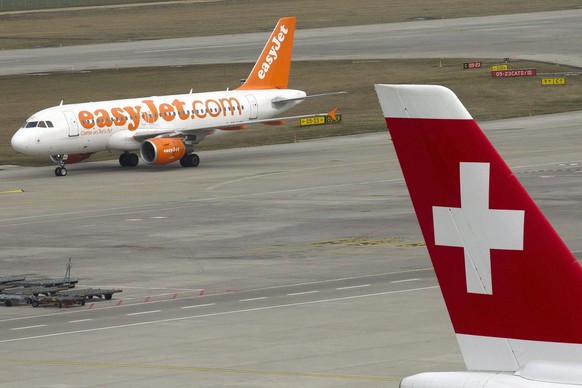 An easyJet Air Line aircraft runs on taxiway behind a Swiss International Air Lines aircraft at Geneva Airport, in Geneva, Switzerland, Tuesday, March 20, 2012. (KEYSTONE/Salvatore Di Nolfi)