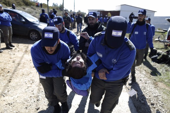 epa05766069 Israeli security forces carry a settler during the evacuation of the settlers from the illegal settlement of Amona in the West Bank, 02 February 2017. Reports state at least 10 Israeli pol ...