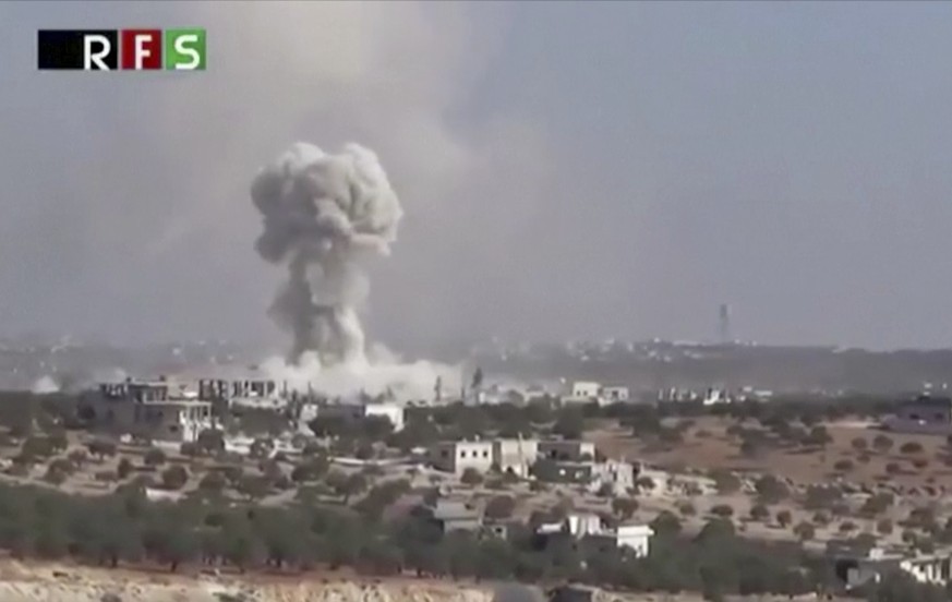 This frame grab from video provided by the Revolutionary Forces of Syria, an opposition activist media organization, that is consistent with independent AP reporting, shows an airstrike on the village ...