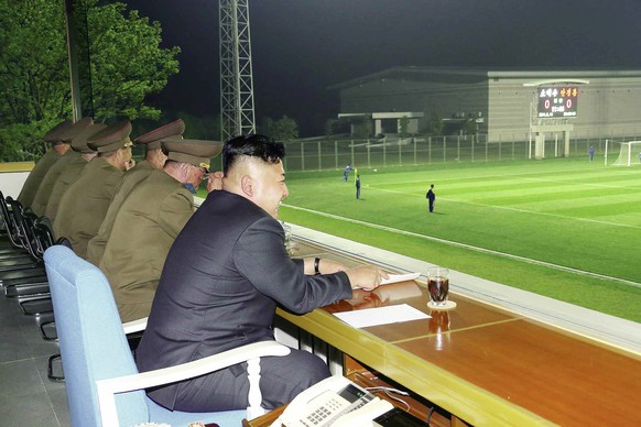 epa04208325 An undated picture released by the North Korean Central News Agency (KCNA) on 16 May 2014 shows North Korean leader Kim Jong-un (R) watching a football match at an undisclosed location in  ...