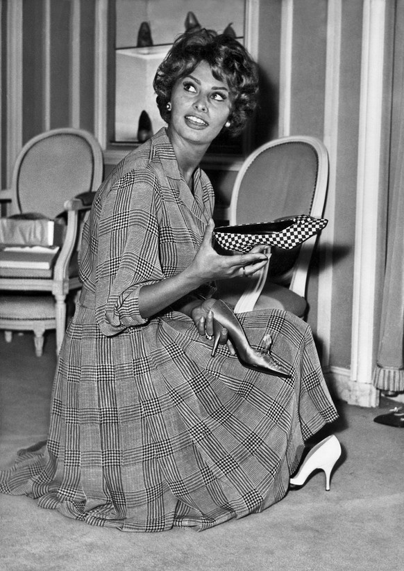 Sophia Loren beim Anprobieren verschiedener Schuhe in einem Geschäft von Christian Dior in Paris, 1958.