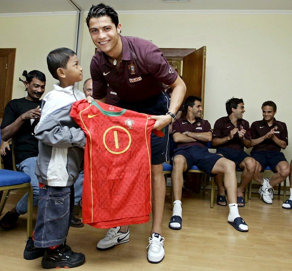 Tsunami survivor Martunis (L) meets the players of the Portuguese national soccer team at the training centre in Oeiras on Thursday, 02 June 2005. Martunis, an Indonesian boy who survived the tsunami  ...