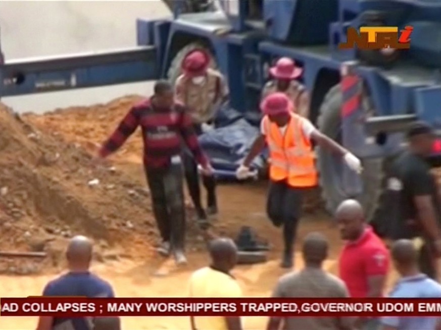 People carry a body on a stretcher after a church collapsed during a service in the southern city of Uyo in Akwa Ibom state, Nigeria in this still image from video December 10, 2016. Video taken Decem ...