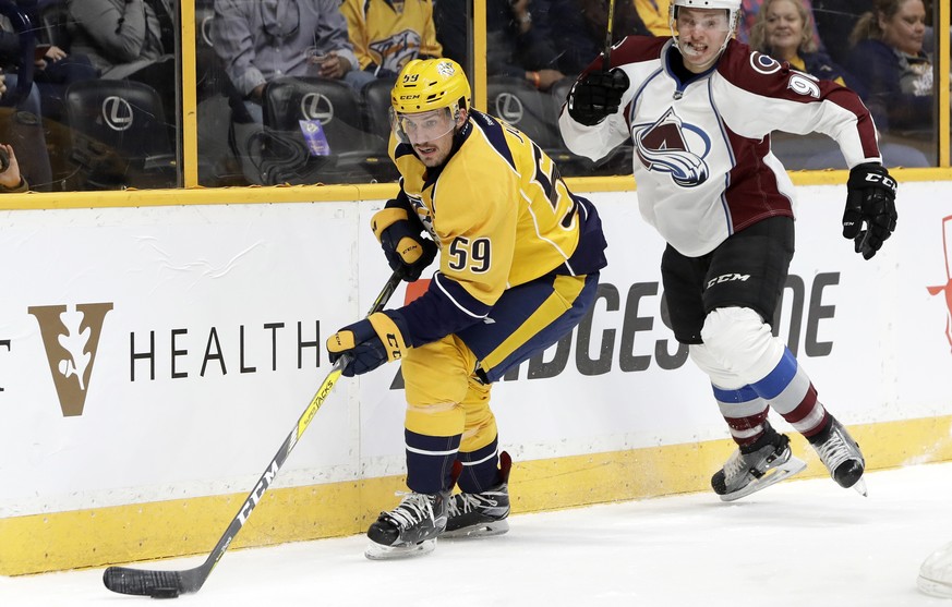 Nashville Predators defenseman Roman Josi (59), of Switzerland, moves the puck ahead of Colorado Avalanche right wing Mikko Rantanen (96), of Finland, during the first period of an NHL hockey game Thu ...