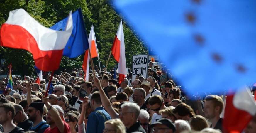 epa06091452 People participate in a protest in front of the Sejm building in Warsaw, Poland, 16 July 2017. The demonstration was organized by Committee for the Defense of Democracy (KOD). Members and  ...