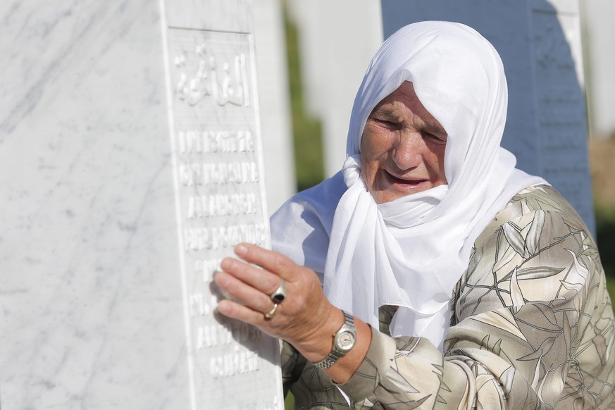 epa04841791 A Bosnian muslim woman cries at the grave of her relative at the Potocari Memorial Center in Srebrenica, Bosnia and Herzegovina, 11 July 2015. The burial of 136 newly-identified Bosnian Mu ...