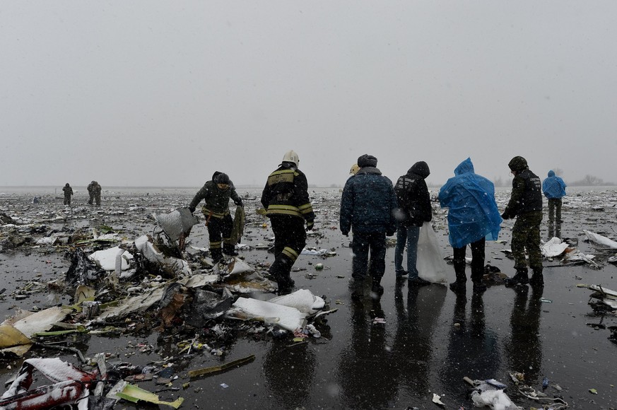 Rettungskräfte untersuchen die Trümmer der Unglücksmaschine.