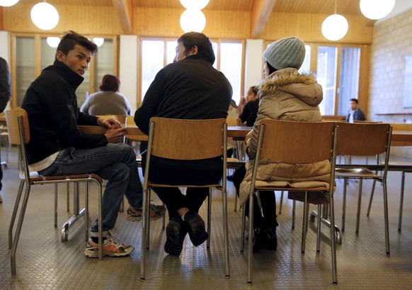 Refugees sit together in the Swiss Army Camp Glaubenberg which is used as a Federal Center for refugees on the Glaubenberg mountain in central Switzerland, December 3, 2015. REUTERS/Ruben Sprich