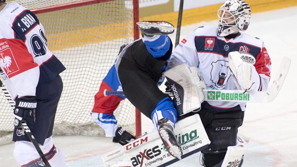 Zug&#039;s Dominic Lammer, center, fights against Berlin&#039;s goalkeeper Marvin Cuepper, right, during the ice hockey Champions League match 1/16 Final between EHC Zug and Eisbaeren Berlin, in Zug,  ...