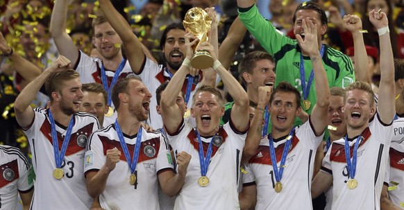 FILE - In this July 13, 2014 file photo Germany&#039;s Bastian Schweinsteiger holds up the World Cup trophy as the team celebrates their 1-0 victor over Argentina after the World Cup final soccer matc ...