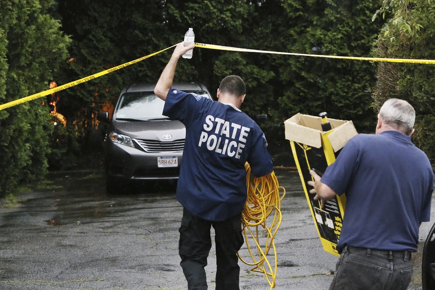 Authorities carry lighting equipment to the backyard of the home of Lillian Webb, wife of fugitive Donald Eugene Webb, in Dartmouth, Mass., Thursday, July 13, 2017. Authorities began a dig at the home ...