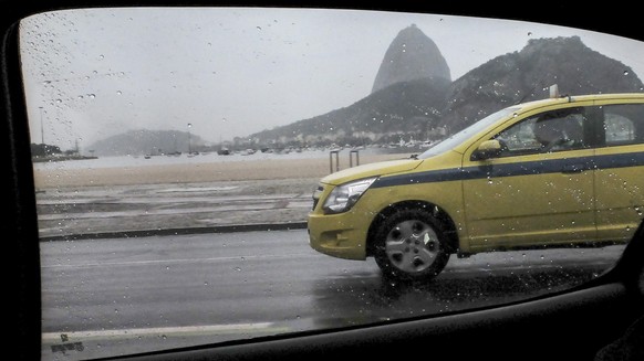 epa05476653 A taxi passes by in light rain along a street during the Rio 2016 Olympic Games in Rio de Janeiro, Brazil, 12 August 2016. Media reports that taxi drivers are planning to strike over the u ...