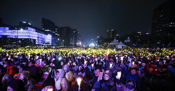 epa05648181 South Koreans shout slogans as they carry placards reading &#039;Park Geun-Hye Out&#039; during a rally against South Korean President Park Geun-Hye on a main street in Seoul, South Korea, ...