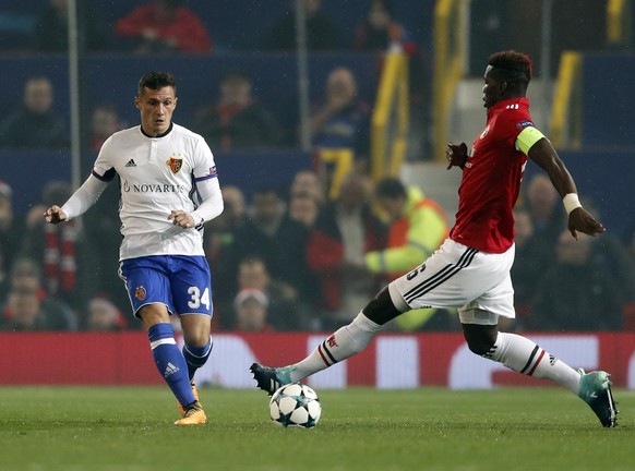 Manchester United&#039;s Paul Pogba, right, is challenged by Basel&#039;s Taulant Xhaka during the Champions League group A soccer match between Manchester United and Basel, at the Old Trafford stadiu ...