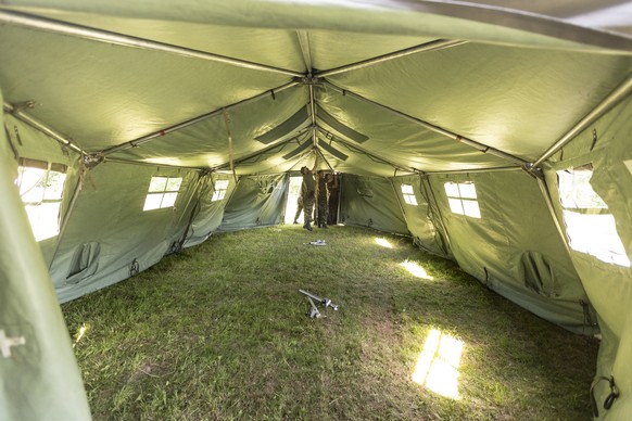 Medical corps members set up a medical tent, pictured on site of the medical corps of the Swiss Armed Forces on June 18, 2013, in Buetschwil, canton of St. Gallen, Switzerland. A medical unit of the a ...