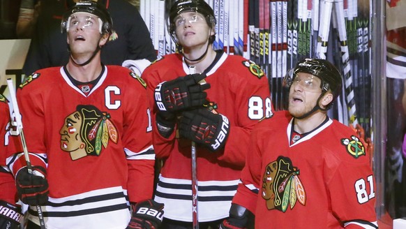Chicago Blackhawks&#039; Jonathan Toews, left, Patrick Kane (88) and Marian Hossa watch a replay of Hossa&#039;s 500th career goal, during the second period of an NHL hockey game against Philadelphia  ...