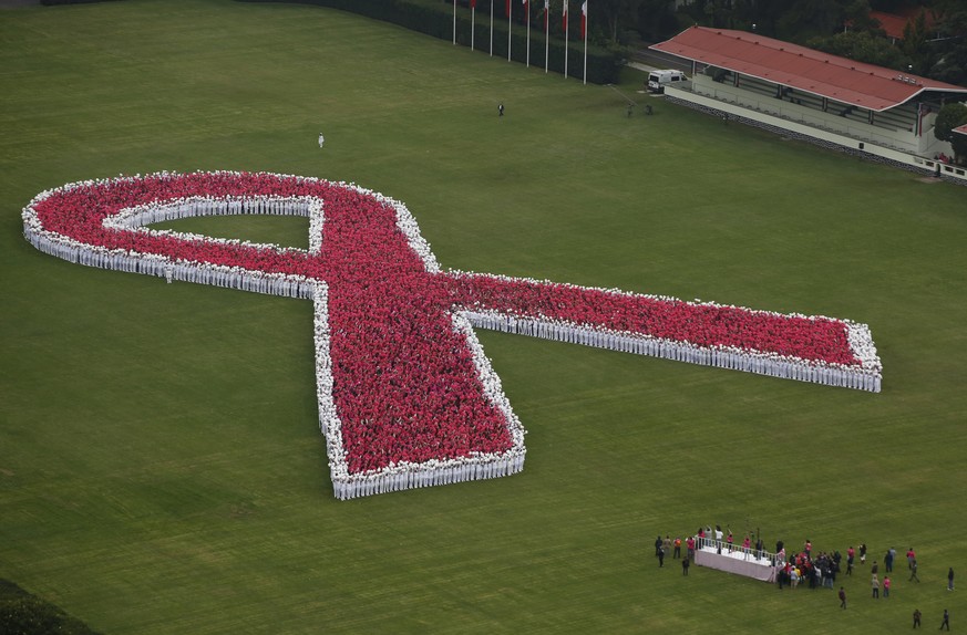 Thousands of people form a giant pink ribbon during an event marking the start of breast cancer awareness month, inside the grounds of a military camp in Mexico City, Saturday, Oct. 1, 2016. Organizer ...