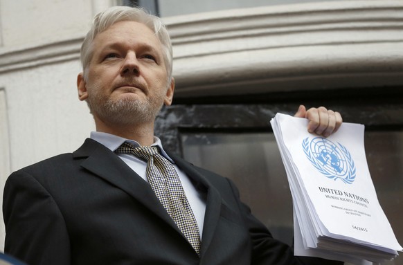 FILE - This is a Friday, Feb. 5, 2016 file photo of WikiLeaks founder Julian Assange holds a U.N. report as he speaks on the balcony of the Ecuadorian Embassy in London. A Swedish appeals court on Fri ...