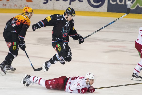 Le defenseur fribourgeois Yannick Rathgeb, gauche, saute au dessus du defenseur lausannois Dario TrutmannÊ, droite, lors du match du championnat suisse de hockey sur glace de National League A, entre  ...