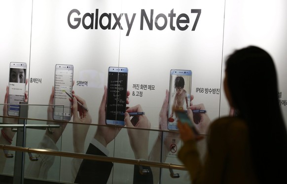 epa05743405 (FILE) - A file picture dated 07 October 2016 shows a South Korean woman walking next to an advertisement of the Samsung Galaxy Note 7 at the Samsung Electronics headquarters in Seoul, Sou ...