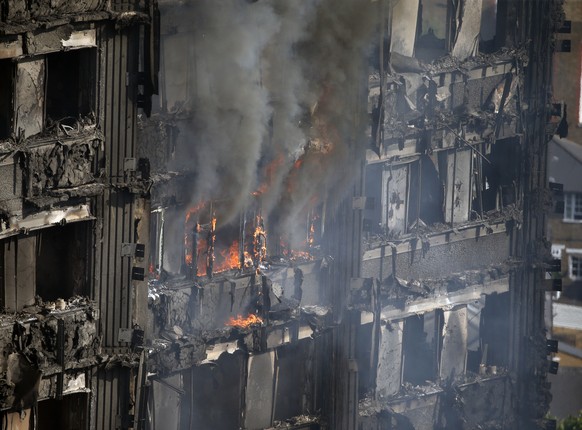 Parts of the building still burn hours after a deadly blaze at a high rise apartment block in London, Wednesday, June 14, 2017. Fire swept through a high-rise apartment building in west London early W ...