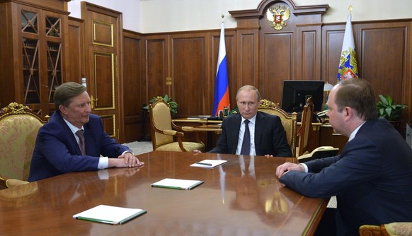 Russian President Vladimir Putin, center, meets with the new Chief of the presidential administration, Anton Vayno, right, and the outgoing Kremlin Chief of Staff, Sergei Ivanov, in the Kremlin in Mos ...