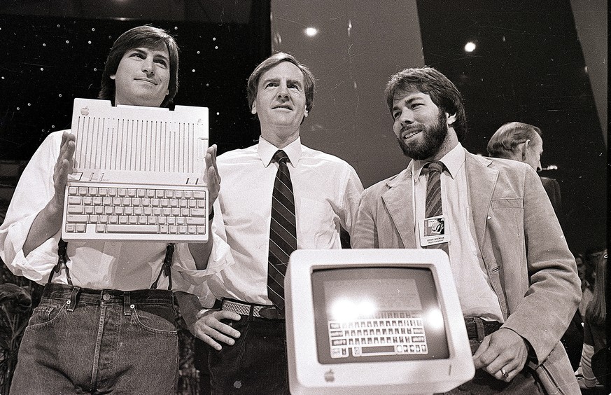 FILE - In this April 24, 1984 file photo, Steve Jobs, left, chairman of Apple Computers, John Sculley, center, president and CEO, and Steve Wozniak, co-founder of Apple, unveil the new Apple IIc compu ...
