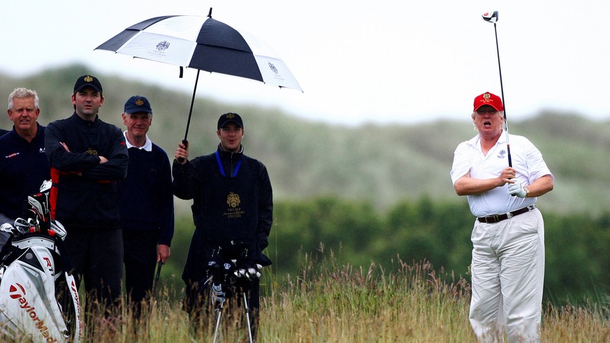 Real estate magnate Donald Trump (R) plays golf during the opening of his Trump International Golf Links golf course near Aberdeen, northeast Scotland July 10, 2012. REUTERS/David Moir/File Photo FROM ...